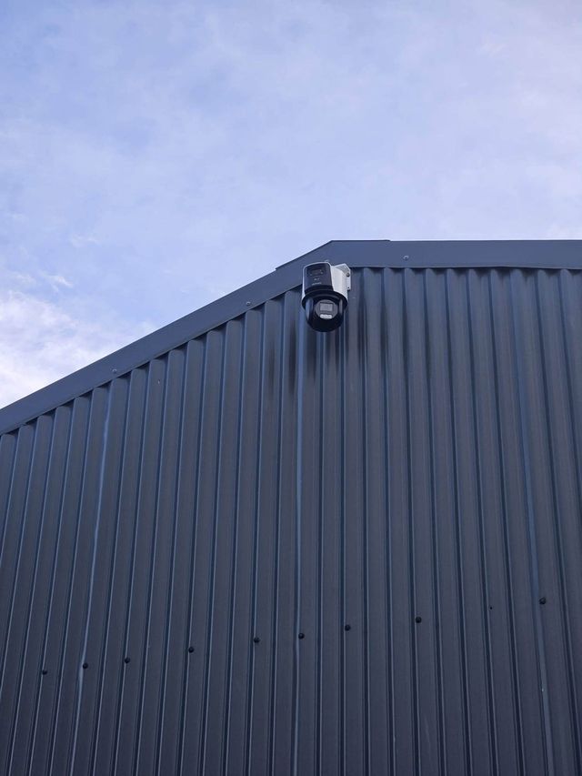 Turret CCTV camera on a dark metal-clad building