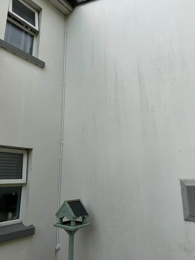 TV system cabling run neatly in white conduit up the outside wall of a housing block