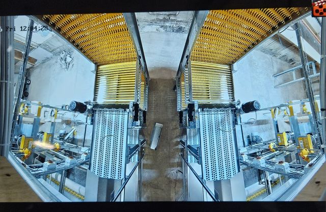 Panoramic CCTV view looking down two rows of poultry house equipment