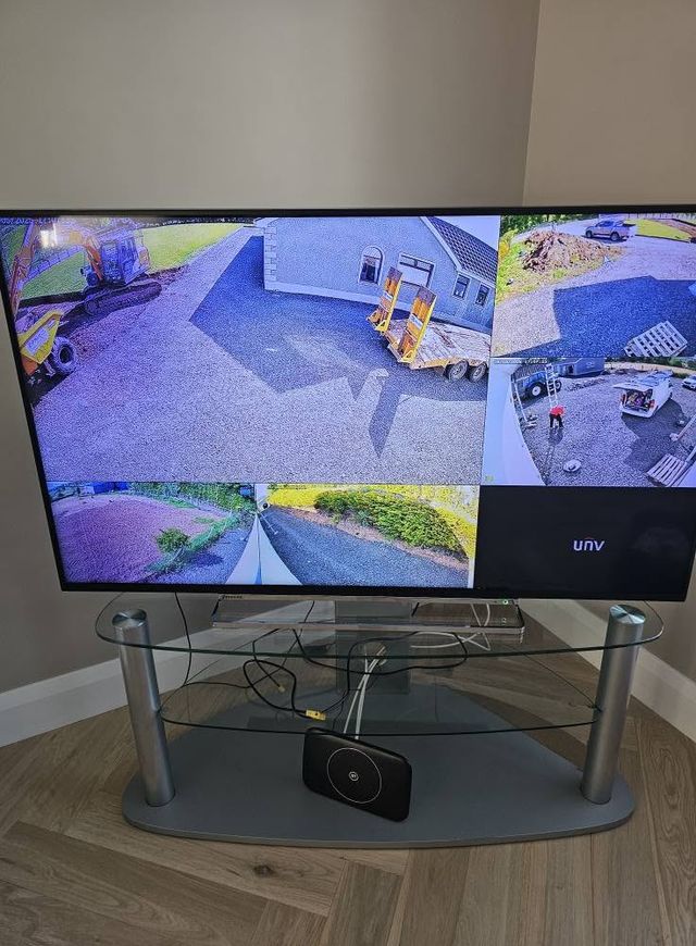 Living room TV showing four CCTV camera views around the property