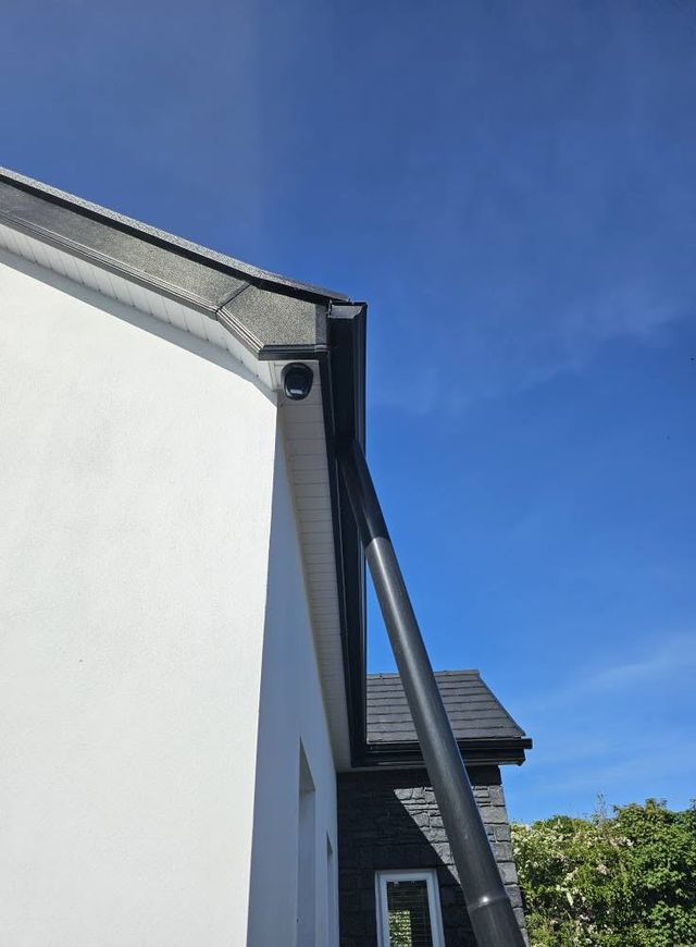 Dome CCTV camera fitted under the soffit of a white house