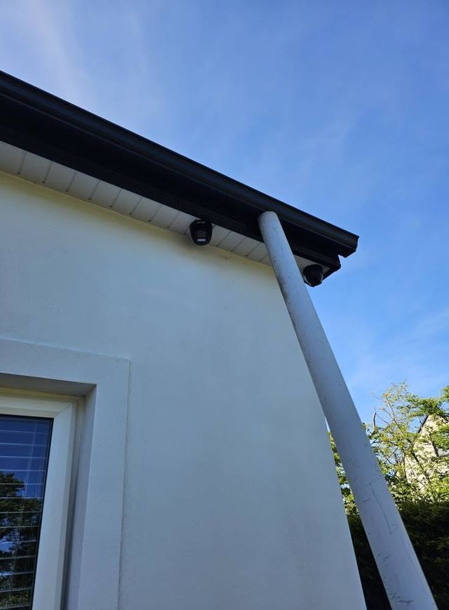 Dome CCTV cameras fitted under the soffit of a white house