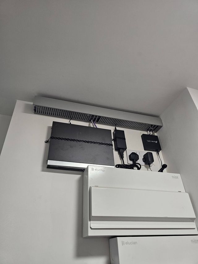 Wall-mounted network switch fitted above the consumer unit