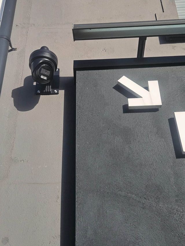Close-up of the IP CCTV camera mounted above the shop front sign
