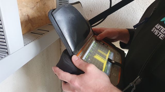 Engineer checking TV signal levels on a spectrum analyser